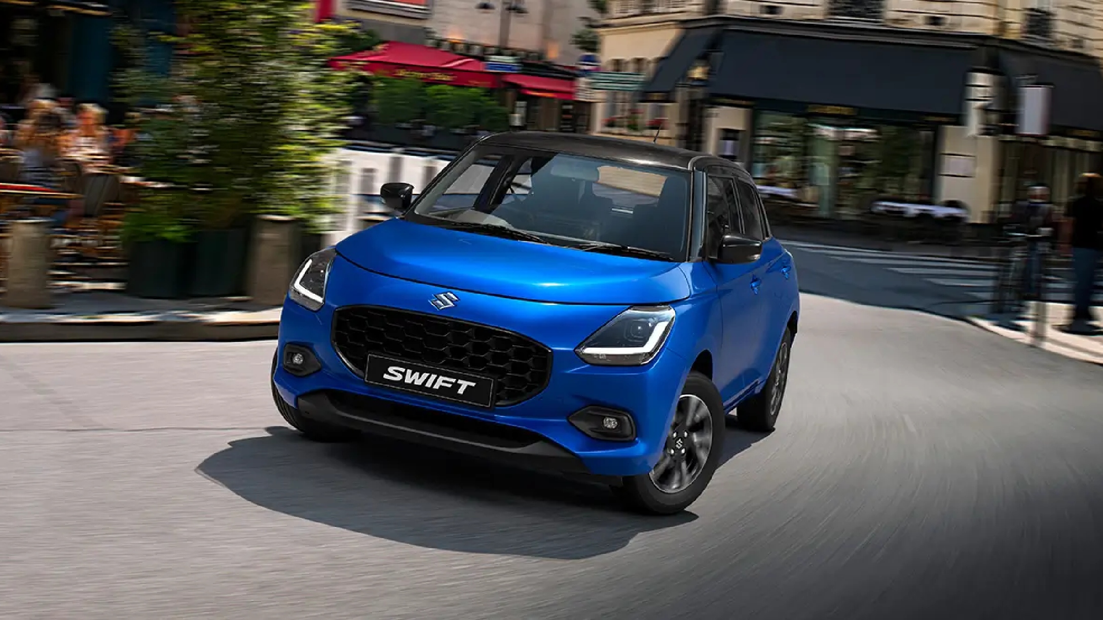 Nuevo Suzuki Swift smart Hybrid color azul siendo conducido por calles de la ciudad.