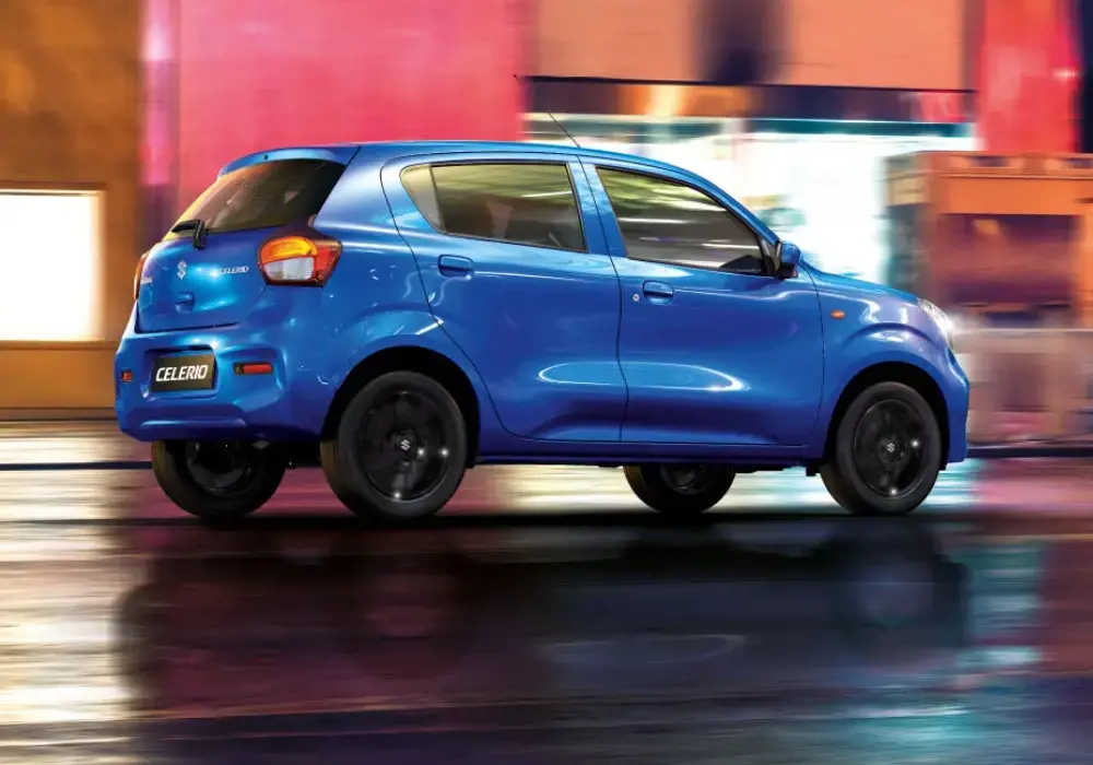 Suzuki Celerio azul en movimiento bajo la lluvia.