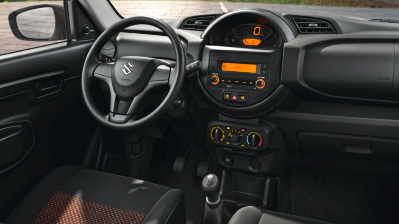 Vista interior de Suzuki S-presso con caja de cambios mecanicamecánica y con vista a montañas.